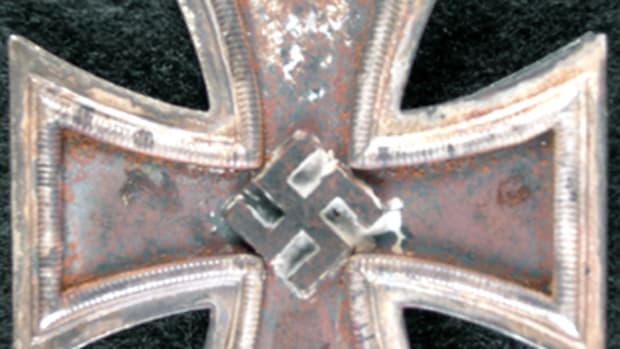 [This image appeared on page 52 of the original article] This is Nowotny’s disfigured and scorched Knights Cross (front & side views Editor’s note: No side view was received) after being retrieved by his wing man Carl “Quax” Schnorrer from his downed Me262.
