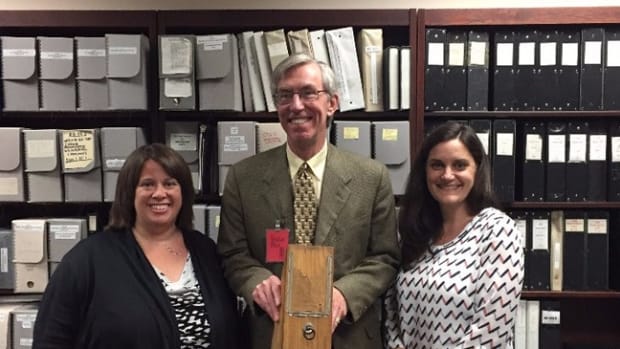  National Archives Catalog Community Managers Suzanne Isaacs (left) and Meredith Doviak (right) with Alex Smith. Mr. Smith is holding a 19th century example of a wooden box used for the storage of records.