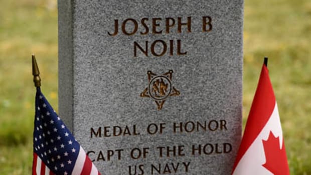 160429-N-TH437-182 WASHINGTON (April 29, 2016) American and Canadian flags are placed at the newly erected headstone of Medal of Honor recipient Joseph B. Noil during a ceremony April 29, 2016 at St. Elizabeths Hospital Cemetery. Noil received the Medal of Honor while serving on USS Powhatan, but his headstone did not recognize his award due to a misprint on his death certificate. (U.S. Navy photo by Mass Communication Specialist 2nd Class Eric Lockwood/Released)