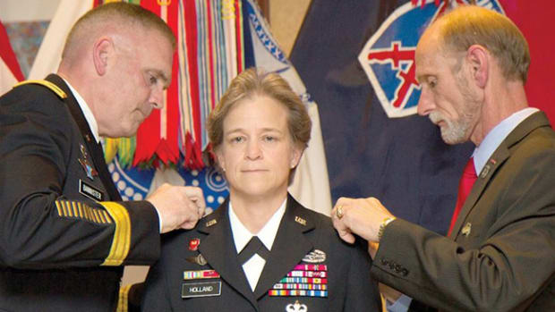 Brig. Gen. Diana Holland becomes the first woman to hold the title of deputy commanding general for support in a light infantry division during her promotion ceremony to brigadier general on Fort Drum, N.Y., July 29, 2015. Her husband, James Holland Jr., right, and Army Maj. Gen. Jeffrey L. Bannister, 10th Mountain Division and Fort Drum commander, pin on her stars.