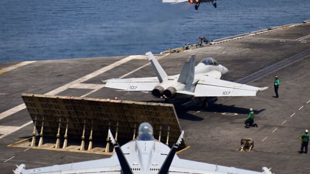  ARABIAN GULF (July 29, 2017) An F/A-18F Super Hornet from, the “Black Knights” of Strike Fighter Squadron (VFA) 154, launches from the flight deck of the aircraft carrier USS Nimitz (CVN 68) while another Super Hornet from the "Black Knights" and an EA-18G Growler, from the “Gray Wolves” of Electronic Attack Squadron (VAQ) 142, prepare to launch, July 29, 2017, in the Arabian Gulf. Nimitz is deployed in the U.S. 5th Fleet area of operations in support of Operation Inherent Resolve. While in this region, the ship and strike group are conducting maritime security operations to reassure allies and partners, preserve freedom of navigation, and maintain the free flow of commerce. (U.S. Navy photo by Mass Communication Specialist 3rd Class Weston A. Mohr)