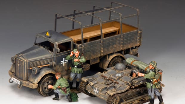These classic Wehrmacht troopers are behind schedule due to some “unscheduled maintenance” on their tinplate Opel ‘BLITZ’.