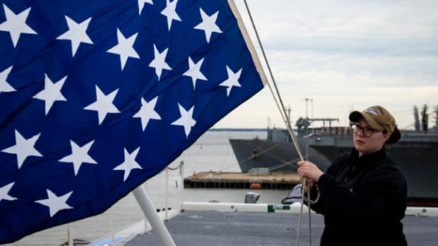  190219-N-QD512-0022NORFOLK (Feb. 19, 2019) Quartermaster 2nd Class Taylor Miller, from Kent, Ohio, unfurls the union jack on the jack staff of the aircraft carrier USS Dwight D. Eisenhower (CVN 69). Dwight D. Eisenhower is undergoing a planned incremental availability during the maintenance phase of the Optimized Fleet Response Plan. (U.S. Navy photo by Mass Communication Specialist 3rd Class Kaleb Sarten/Released)