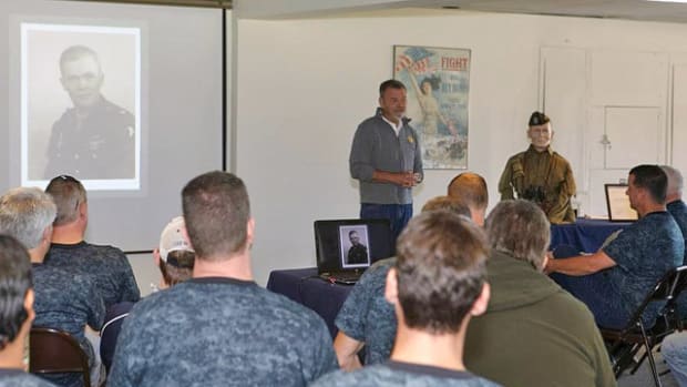 Bill Shea of The Ruptured Duck making a presentation to a group of young executives at the Collings Foundation in Stow, MA. His talk was centered around leadership. Major Dick Winters from E Company, 506 Parachute Infantry Regiment is being discussed.