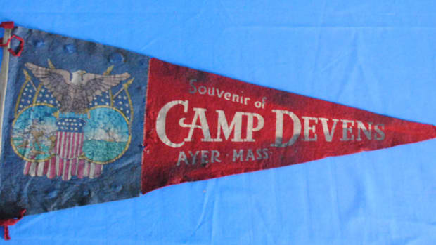  One of the more colorful, but harder to find in good condition, souvenirs purchased by the soldiers are the felt and cotton pennants made for units or training camps. This camp Devens example gives some hint of the original colors but has suffered a lot of damage over the years.