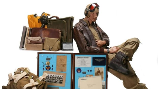 Important 75-piece archive of personal and service items belonging to Tuskegee Airman William S. Powell Jr. Uniform includes A-2 leather jacket with squadron patch and name, flight suit and other apparel with all insignia, parachute, kit bag, flight log, many documents including Tuskegee diploma with signatures of classmates and instructors.