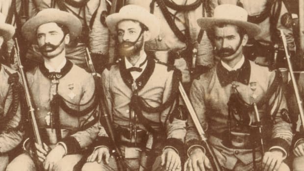 A detail view of a group photograph of the Gastadores section of the 2nd Havana Volunteer Infantry Regiment taken about 1895. The Modelo 1843 Infantry machete of the soldier in the center is clearly visible. Note also the crossed tools sleeve insignia and the thick aiguillette, all symbols identifying these elite Spanish Pioneer Infantrymen.