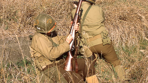 Two WWII US reenactors firing / loading M1 Garands