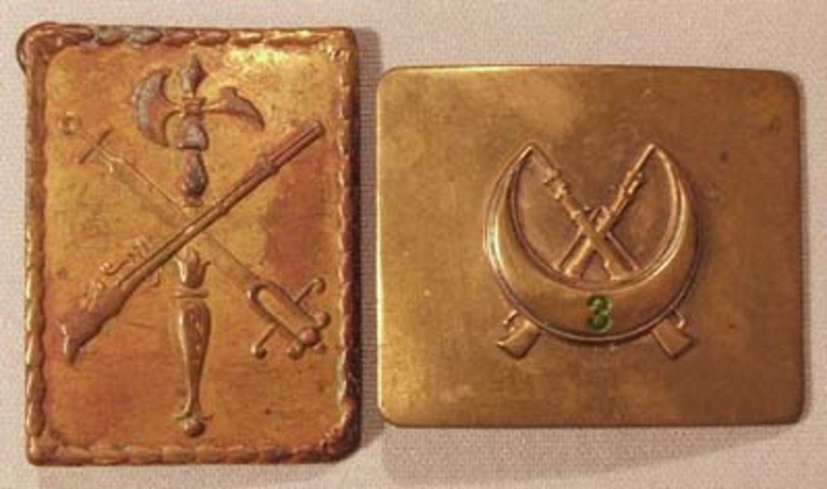 Belt plates of the Nationalist Elite and the Army of Africa. In the 1930s, Spain still had large colonial holdings in western North Africa. The forces that controlled this region were the Spanish Foreign Legion and indigenous Muslim troops, most notably the Moroccan Infantry known as the "Regulares." At the beginning of the uprising, these troops declared unanimously for the rebel Nationalists and would prove to be the best storm troops of the war. The plate on the left is embossed with the emblem of the Spanish Foreign Legion, a trophy of medieval weapons. The plate of the 3rd Regiment of Regulares on the right has the unit number painted in green on the crescent moon of Islam over crossed Mauser rifles.
