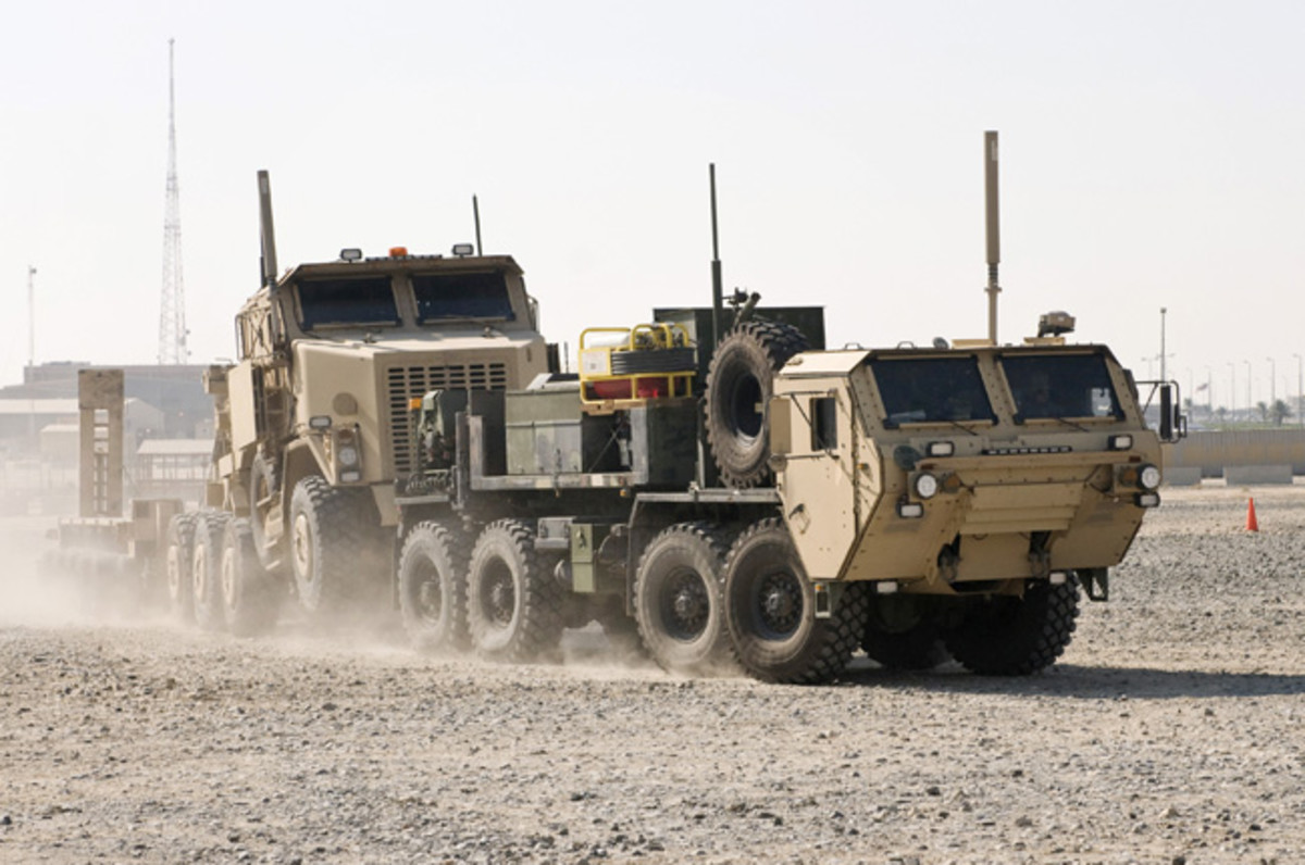  A Heavy Expanded Mobility Tactical Truck Wrecker tows a Heavy Equipment Transporter and trailer during a training exercise at Camp Arifjan, Kuwait. The trucks and the Soldiers who drive them make frequent trips into Iraq, retrieving equipment such as humvees, tanks and Mine Resistant Ambush Protected vehicles.