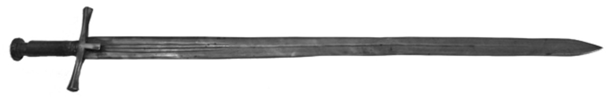  A classic example of the kaskara, the swordmost associated with the Sudan. It features a cross-hilt with straight, double edged blade.