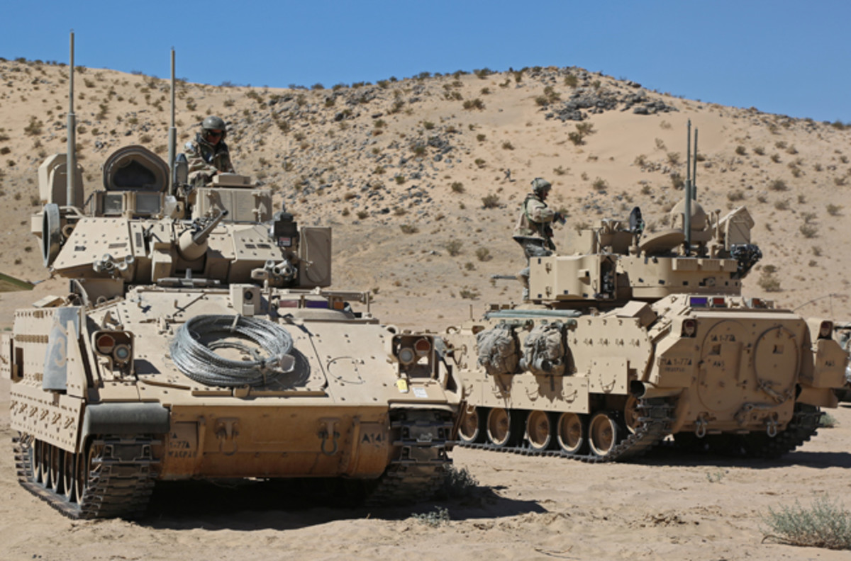  U.S. Army Soldiers from Alpha Company, 1st Battalion 77th Armored Regiment, maneuver their Bradleys into position during Decisive Action Rotation 14-10 at the National Training Center in Fort Irwin, Calif., Sept. 23, 2014. The decisive action training environment rotations were developed to create a common training scenario for use throughout the Army. (U.S. Army photo by Sgt. Charles Probst)