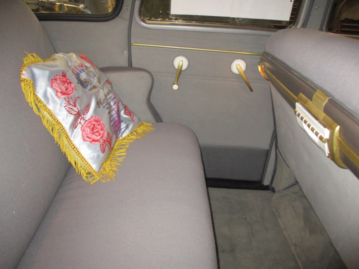 The new interior looks just the way it did in 1942. Some of the details visible here are the rear ash tray with cigar lighter, rear lights on back of the seat, and the original WWII sweetheart pillows. The restored door panels feature the gold trim found throughout the car.