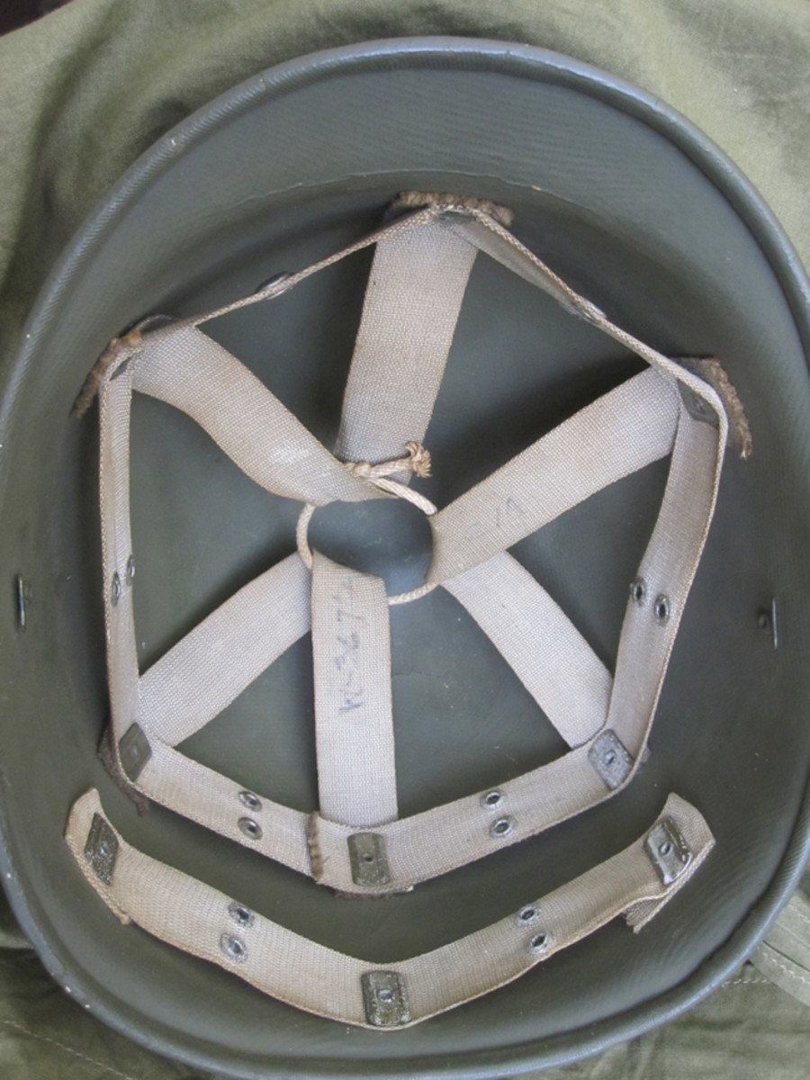The interior of most fiber liners very distinct thicker rim is the most obvious interior difference from the later low and high pressure liners which replaced it. This example is equipped with the early rayon suspension and permanent chinstrap loops on the left and right sides of the liner. 