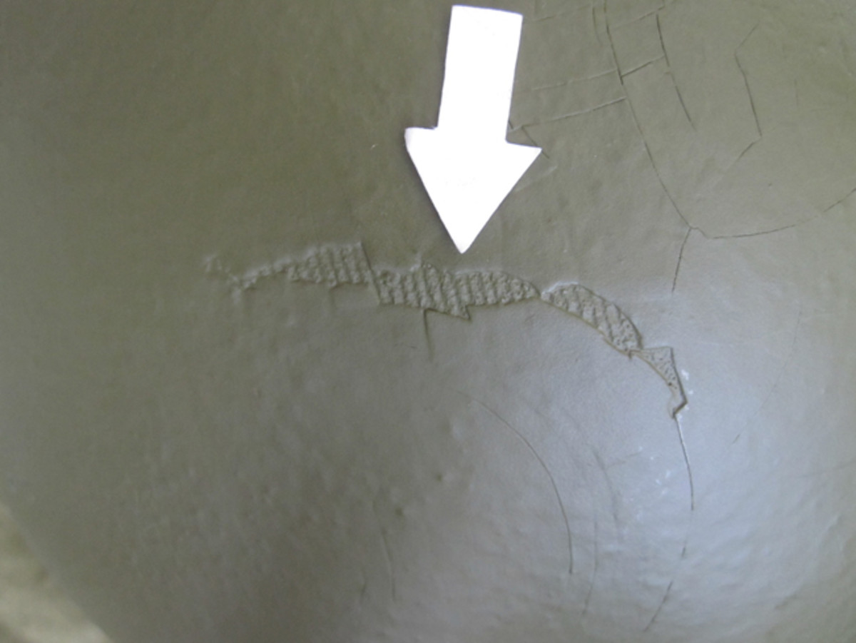 This example of a fiber liner has seen multiple coats of paint during its service life but the grooved pattern of the original textile exterior can be seen through a chip in the paint. 