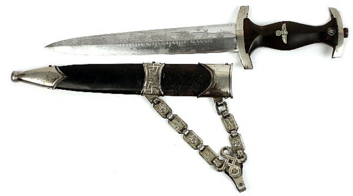 WWII German 1936 chained SS dagger, purchased by seller directly from WWII veteran. No makers marks, SS motto on blade. Some scabbard wear to blade, and loss to enamel on scabbard. Repaired crack in handle next to SS roundel. Overall good example. Estimated Price: $2,500-$2,800.