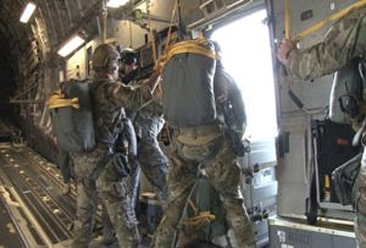  During Airborne operational testing at Fort Bragg, N.C., “Black Falcon” Soldiers of Headquarters and Headquarters Battery, 2nd Battalion, 319th Field Artillery Regiment, get ready to push a Joint Effects Targeting System (JETS) door bundle out of an airplane. After landing, they will test to make sure JETS still functions after the jump. (U.S. Army file photo)