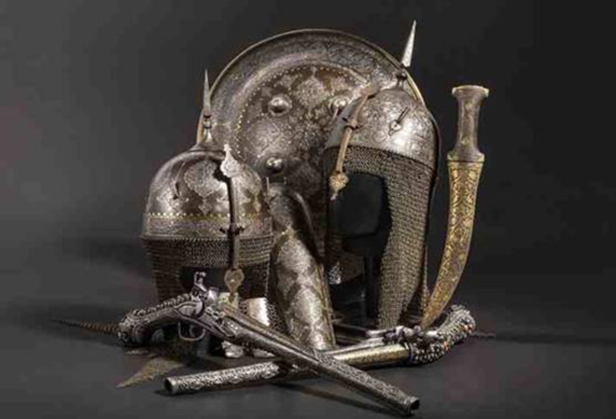  From the selection of oriental arms and armours:Chiselled Persian set, inlaid in gold and comprising helmet, shield and forearm guard, from the 19th century.