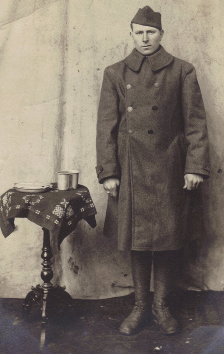  An unidentified Doughboy poses for a formal portrait with his mess kit and canteen cup in a French studio.
