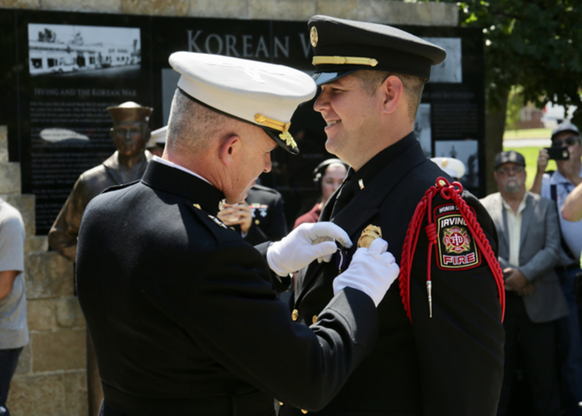  Retired Marine Staff Sgt. Eric Smith is awarded the Navy Cross by Maj. Gen. Paul J. Kennedy during a ceremony in Irving, Texas, Sept. 14. Smith was awarded the Navy Cross for courageous actions in 2004 while serving as a squad leader with Company E, Second Battalion, Fourth Marine Regiment, First Marine Division, in support of Operation Iraqi Freedom. Smith currently serves as a lieutenant paramedic with the Irving Fire Department. Kennedy is the commanding general of Marine Corps Recruiting Command and commanded 2nd Battalion, Fourth Marines at the time of Smith's actions. The Navy Cross is the second highest military decoration that may be awarded to a member of the United States Navy.