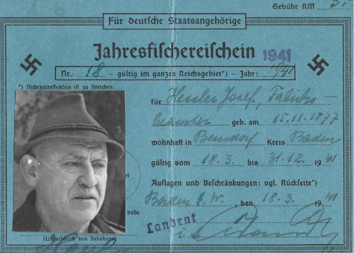  This annual fishing license for a German citizen is printed on blue, medium card stock, measuring about 15cm x 10cm. The document has a postcard-style format. This particular license was issued on 15 November 1941 by the district administrative office to 42-year old Josef Hessler, a factory worker in the town of Berndorf in the district of Baden near Vienna (Kreis Baden bei Wien) in the Reich Province of Lower Danube (Reichsgau Niederdonau). There was a 3 Reichsmark fee for the license.