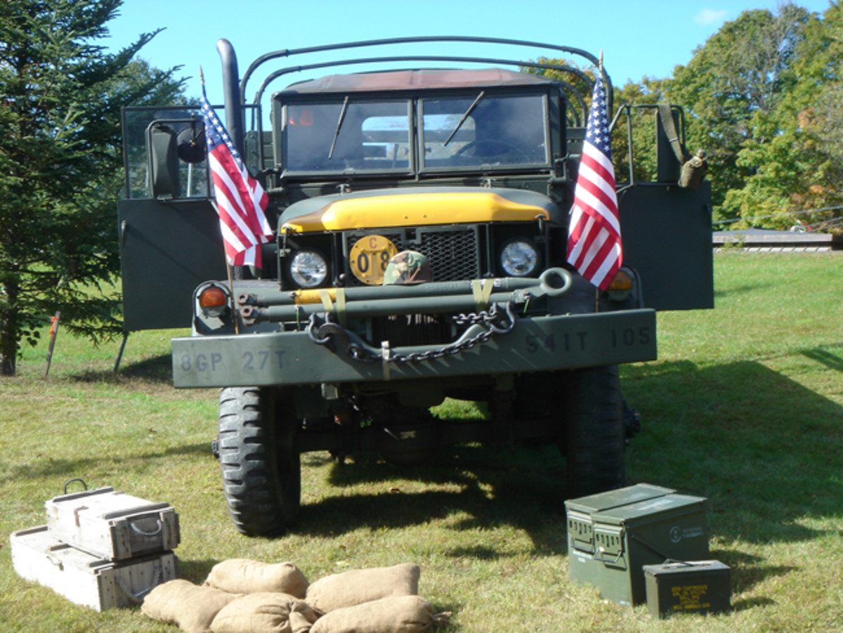 M35 6x6 truck with yellow nose and flags on the fenders.