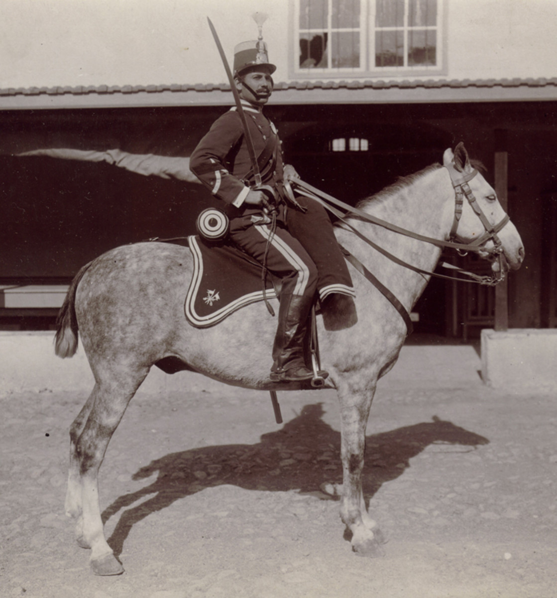 A 1907 dated image of  a Light Cavalryman. This time from a regiment that wore a silver trimmed sky blue shako. The headgear of the Cazadores de Caballería ran the spectrum from shako to fur busby to metal spiked helmet depending on the regiment. The uniform is sky blue trimmed white. His mount is decked out in  regulation horse furniture, also sky blue with white trim and the Cavalry branch insignia. He is armed with a Model 1895 Cavalry saber.