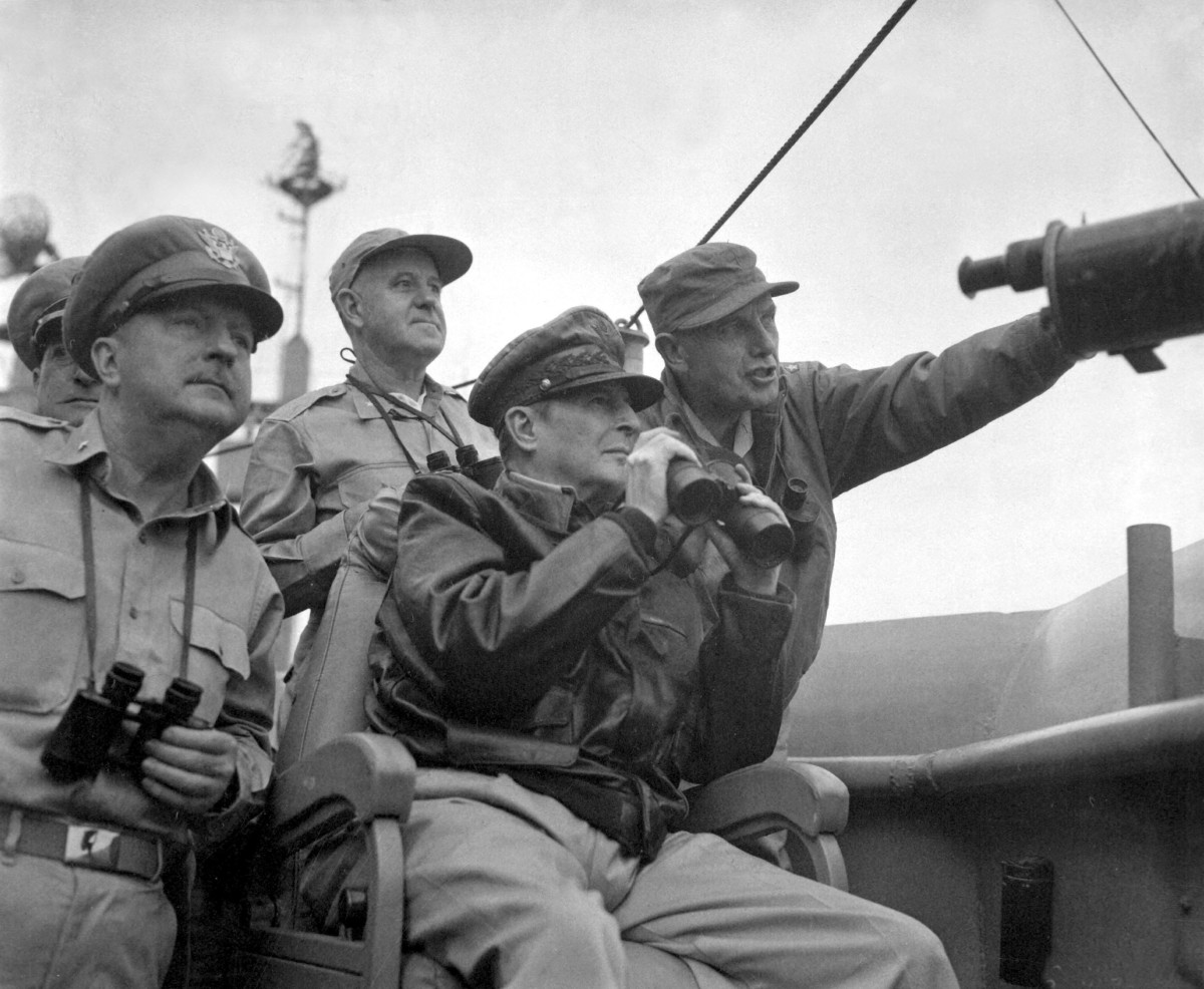 Brigadier General Courtney Whitney, government section, Far East Command; General Douglas MacArthur, Commander-in-Chief, United Nations Command, and Major General Edward Almond (at right, pointing), Commanding General, X Corps in Korea, observe the shelling of Incheon from the USS Mount McKinley (AGC-7), 15 September 1950.