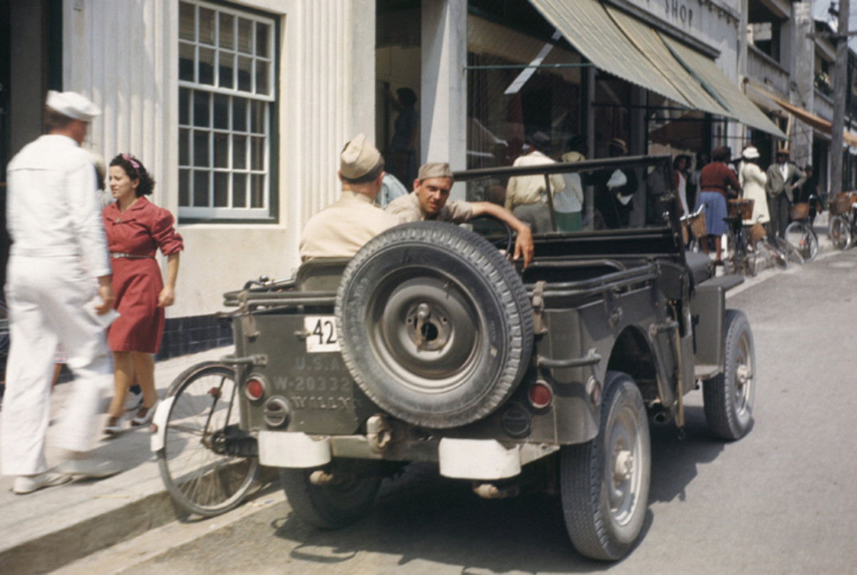 BERMUDA - 1943:  A sailor from the US Naval Battleship USS Iowa known as 'The Big Stick' passes a Willey's Jeep while on shore leave in 1943 in Bermuda.