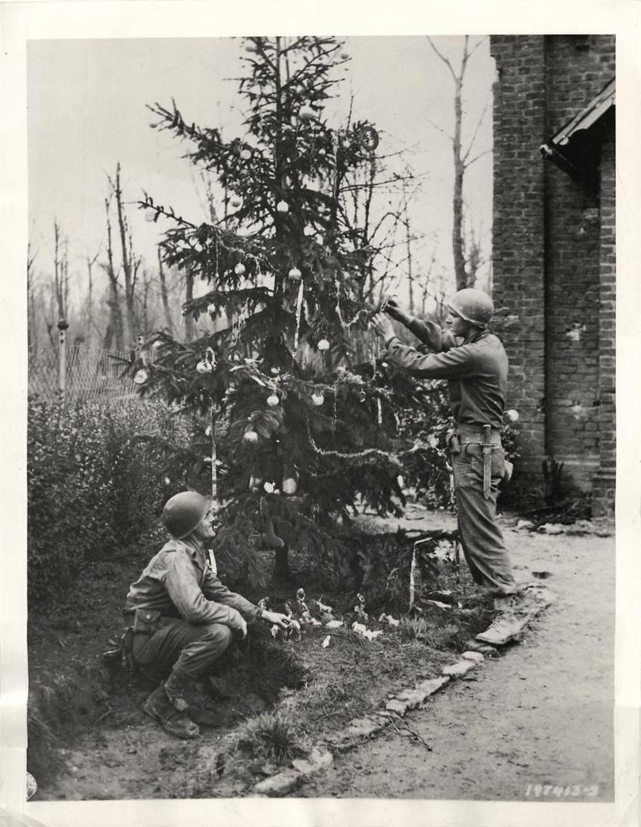Private Robert Frick and Pvt Robert Engelman, both of Philadelphia, decorate a Christmas tree with trimmings from German homes in the captured town of Heren, December 21, 1944.