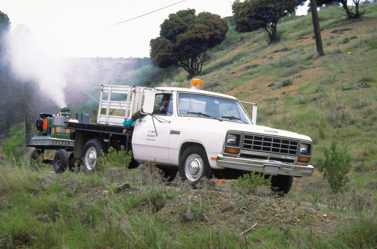 A white Navy Disease Vector Control Office Dodge spraying an area for mosquitoes in 2014.