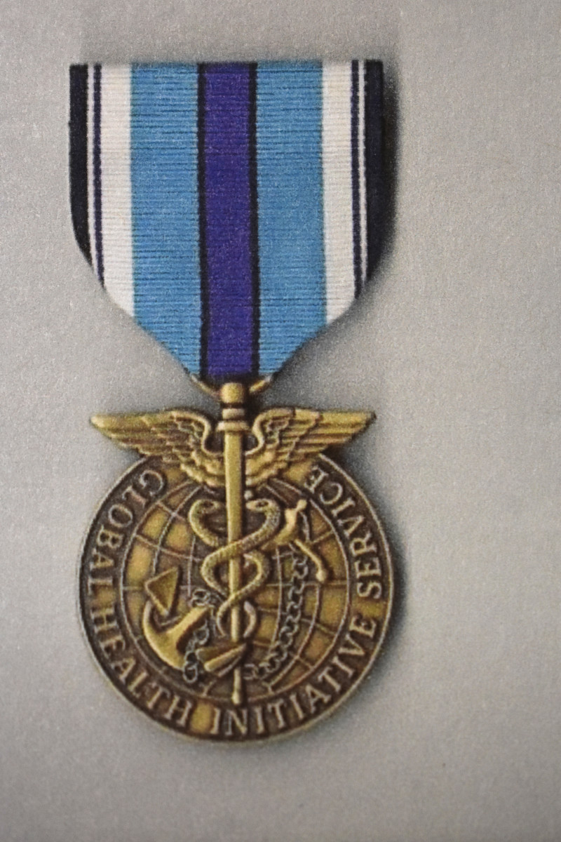 The obverse of the Global Health Initiative medal shows a striking winged design.