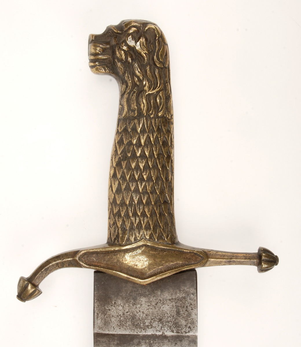 The brass hilt of the Infantry machete sports a lion’s head pommel. The center diamond shaped area of the cross guard can be found with embossed unit numbers, initials or branch insignia. Similar machetes were issued to some non-military, government agencies. The cross guard should be straight, the bent arm on this one is the result of a blow in service. The blade on this example is unmarked.