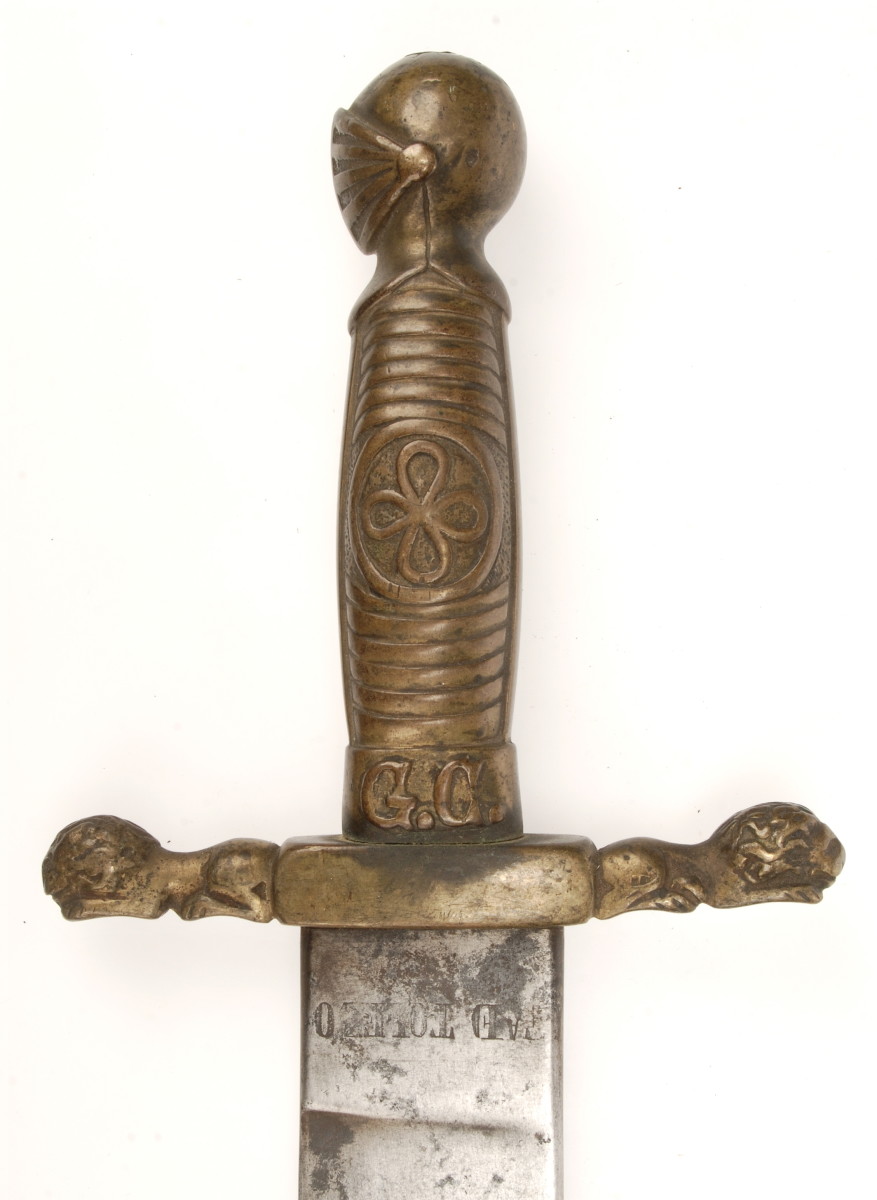 The symbolism of the knight’s helmet and the reclining lions were all intended to project the power and authority of the King and state on the brass hilt of this Modelo 1859 Civil Guard machete. Notice the initials “G.C.” for Guardia Civil on the grip’s ferrule. Produced for only five years, the Civil Guard is the rarest of the M1843 series. This weapon was forged at Toledo in 1863.