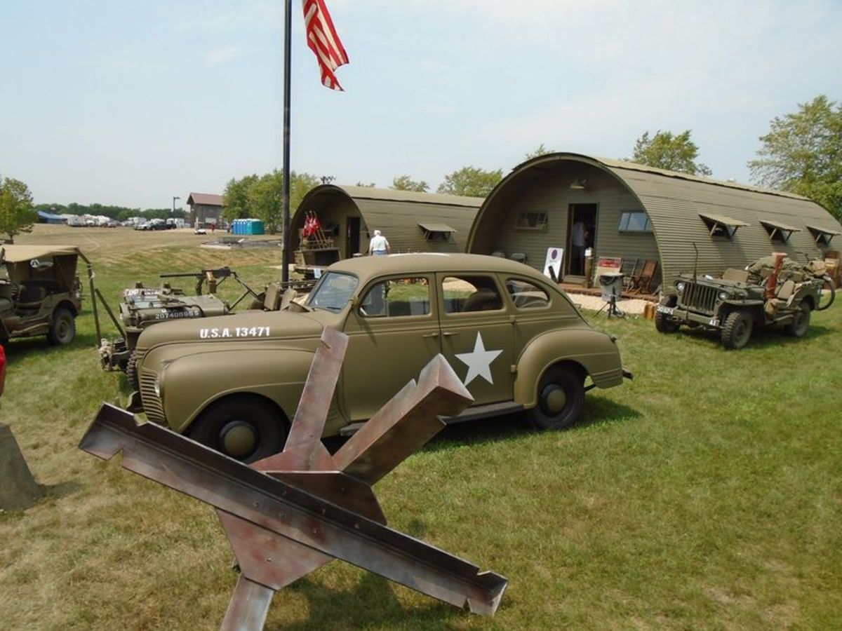 Two quonset huts, a staff car and Jeep.