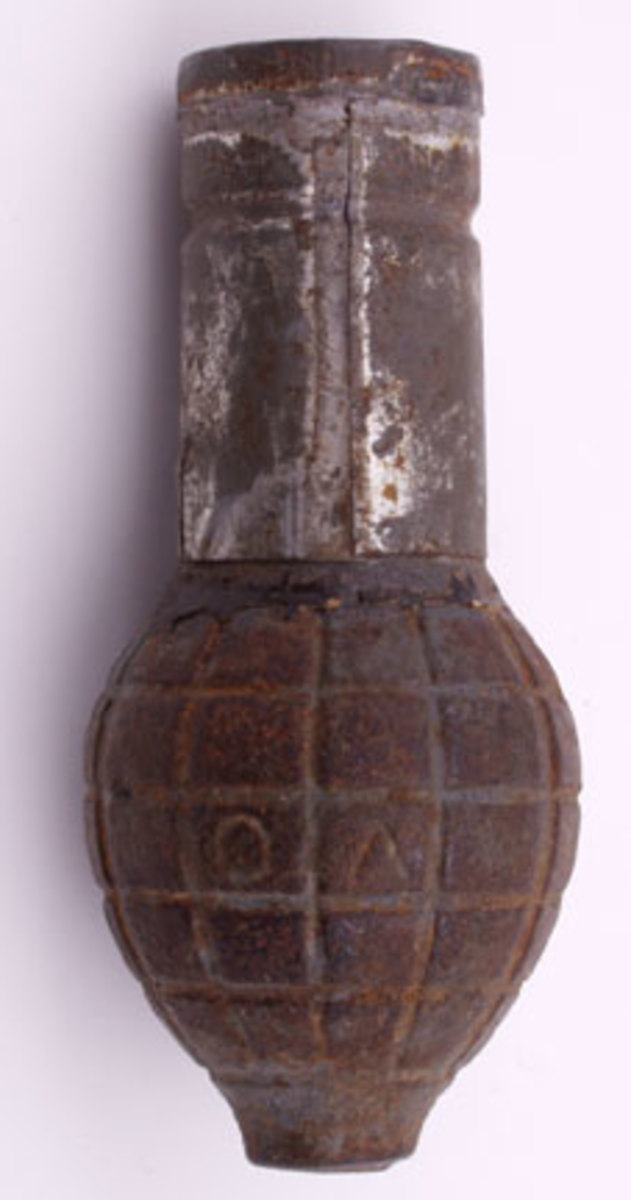 Segmented iron 'Citron Foug' grenade with traces of blue-gray paint and.original tinned iron safety cap, The base had adhesive applied to attach to the grenade body.
