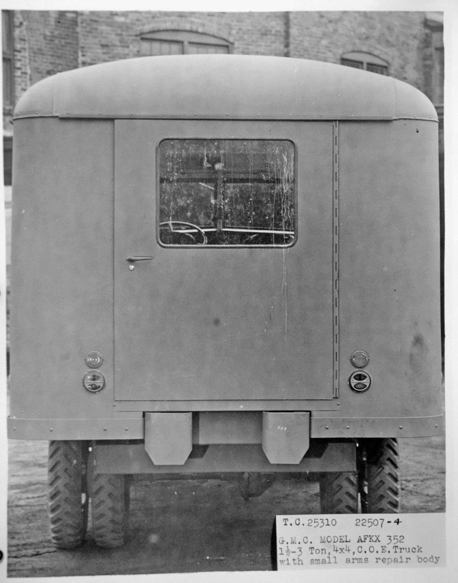 On the rear of the vehicle are a crew door with a piano hinge on the right side and a window and a latch handle, below which is a chromed or bright metal door lock. Two taillights and two reflectors are to the sides of the bottom of the door. The bumperettes have beveled lower corners.