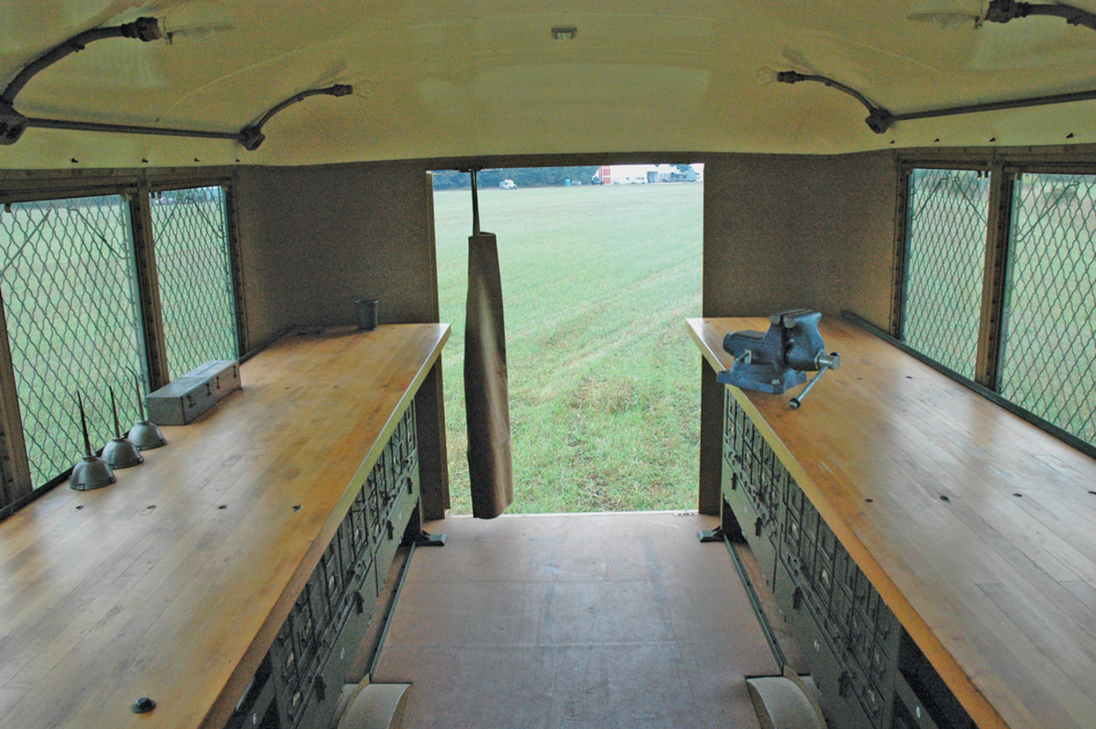 Both workbenches are viewed from behind the cab seats. The floor appears to be Masonite.