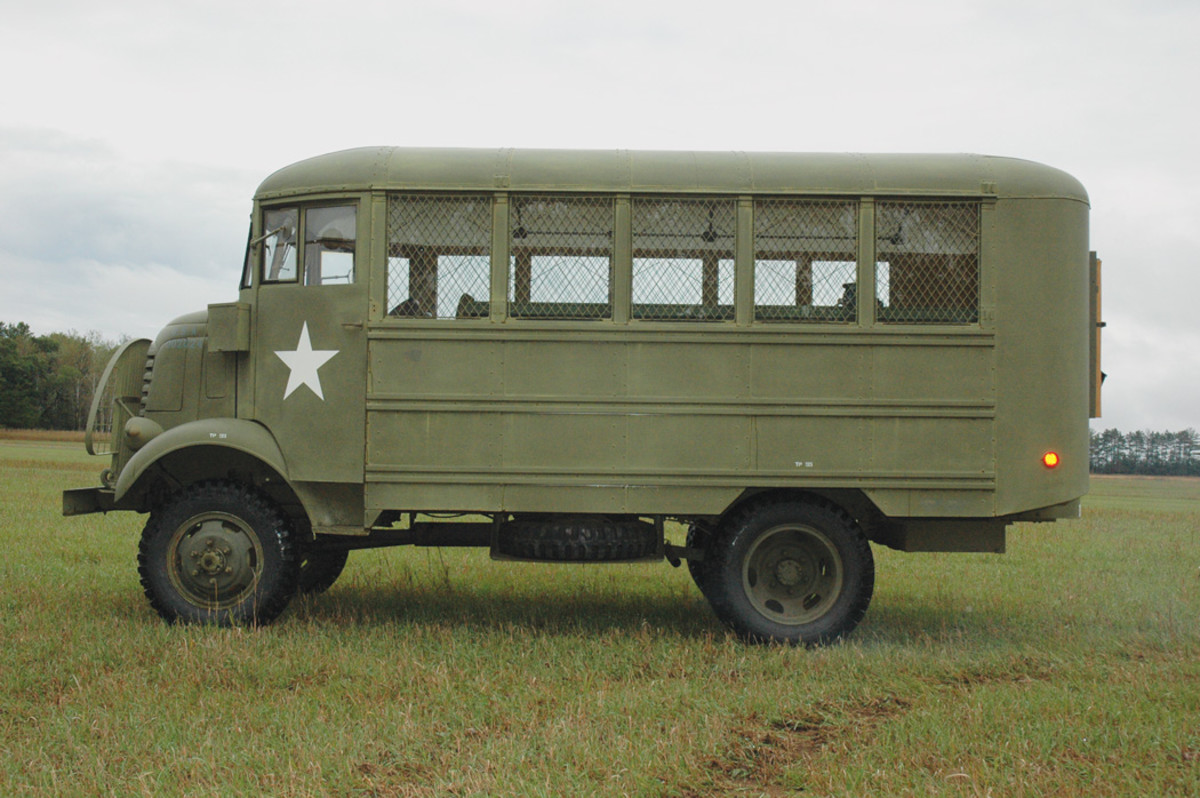 An overall view of the left side of the AFKX-352 provides an idea of the relative positions of the electrical breaker box, the spare tire, and the tool box. The cab doors were curved on the lower front corners, to clear the fenders. On the shop body, below the windows are three horizontal stiffeners, each stiffener having two raised elements with a recess between them. 