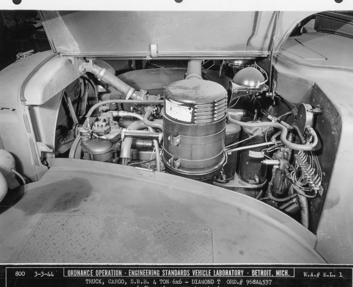 The engine compartment of Diamond T serial number 968A4537 is viewed from the left side. In the center foreground is the United oil-bath air cleaner. To the left are the finned-tube radiator and the six-bladed, belt-driven fan. To the rear of the left side of the radiator is the crankcase breather filter. To the rear of the air cleaner are the engine oil filters.