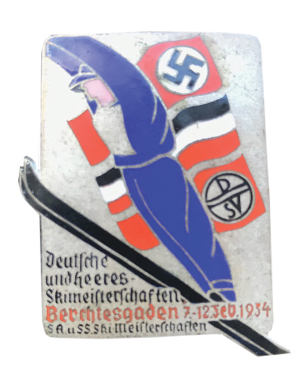 This variation of the 1934 SA-SS Ski Competition Badge is also constructed of silvered bronze with enamel features and displays the same picture and information as the previous badge. It is approximately 45 X 36 mm and has a horizontal pin on the reverse. These badges can be found for around $150.
