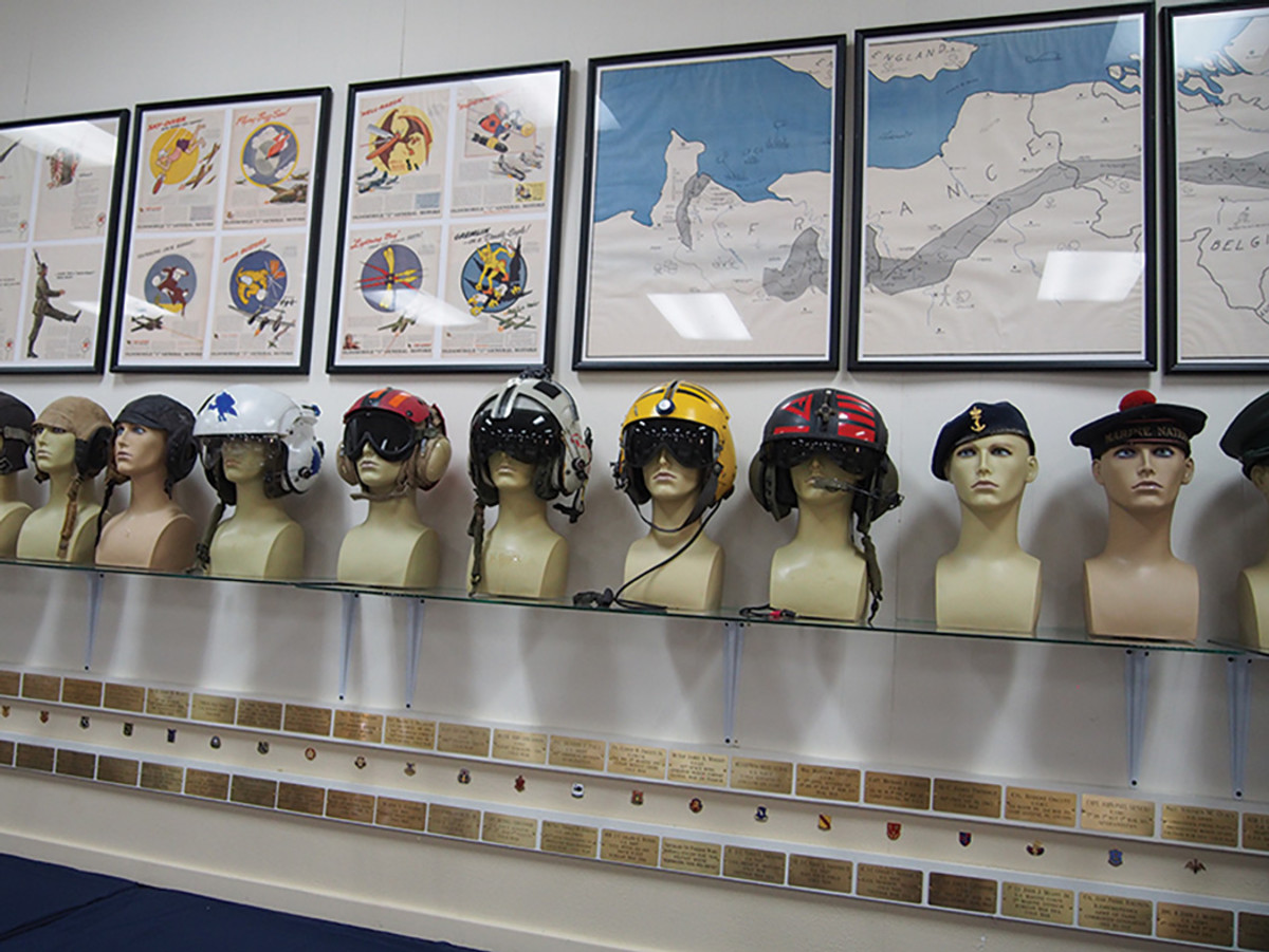 A diverse representation of headgear shows all branches and units from pilots to sailors to infantry.