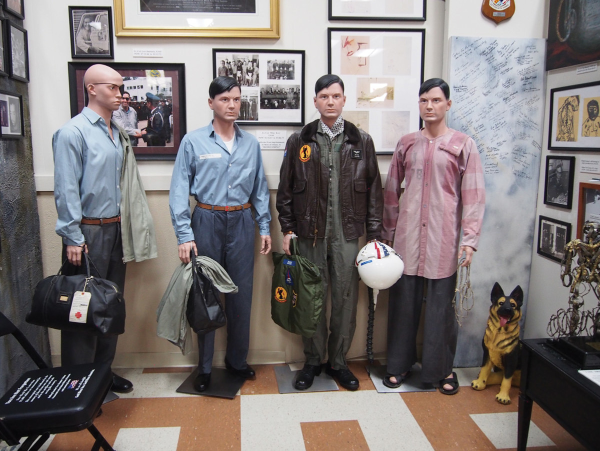 The four men in this exhibit represent the same pilot, dressed in his service uniform, POW prison clothes, release outfit, and the uniform the airman wore when he returned to service.