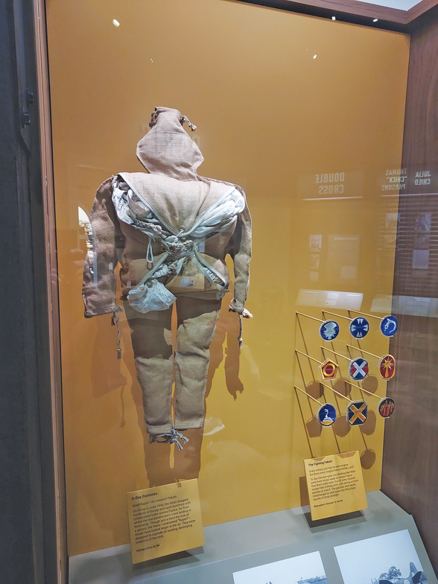 The International Spy Museum’s collection includes a few artifacts that showcase the Allied D-Day deception efforts, including a “Rupert” dummy, the decoys dropped across Northern France on the early hours of the morning to confuse the Germans about where the actual Allied paratroopers were landing. In addition, the museum has on display a number of U.S. Army shoulder patches for units that never existed. Those “phantom units” existed only on paper, but were also meant to convince the Germans that an invasion force was being built up in eastern England for a landing near Calais.