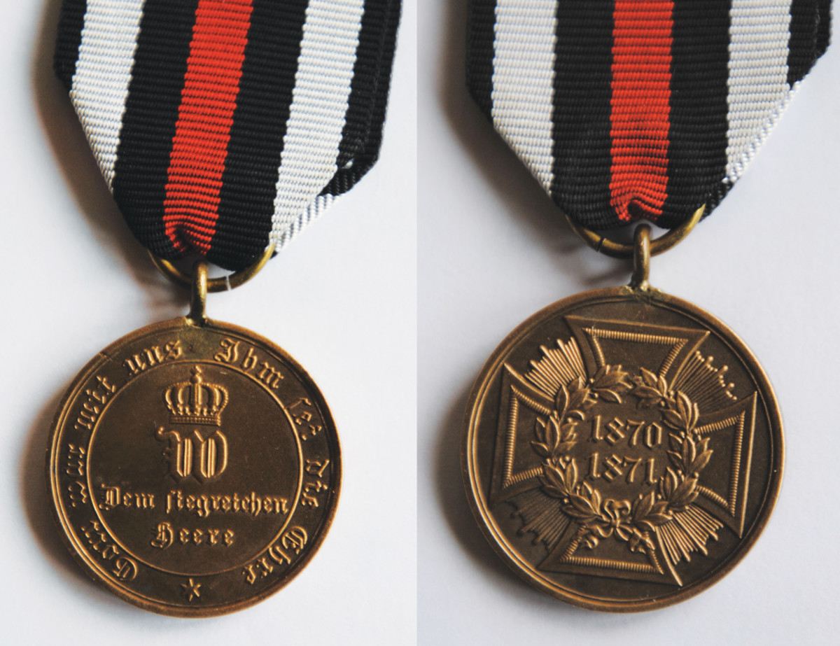 Kaiser Wilhelm I, whose reign as Emperor began on 18 January 1871 at Versailles, instituted the medal known as Kriegsdenkmunze fur die Feldzuge 1870-71 (War Commemorative Medal 1870-71). The obverse has the motto and an otherwise simple design. There are some slight damage marks to the edge which would affect the price. The reverse of the medal shows the intricacies of the design.