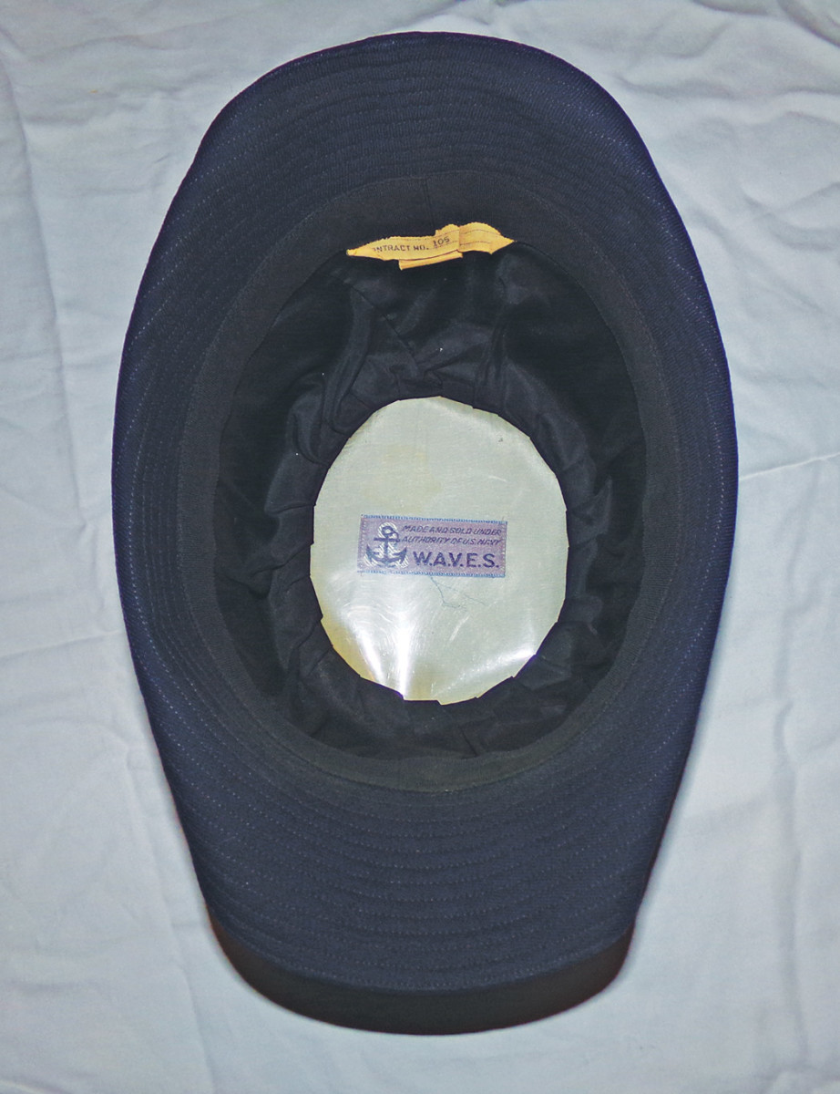 The inside of the officer’s cap shows the light and dark blue  WAVE label  and contract number.