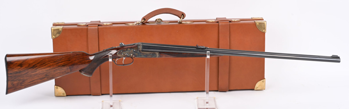 Circa 1890s Holland & Holland Royal Hammerless 450/400 Express double rifle with highly figured English walnut stocks, profuse engraving in tight rose-and-scroll pattern with finely chiseled border. Birmingham proofed and marked ‘400 EX’ with rifle’s serial number. Beautifully restored. Housed in fine oak and leather travel case with Holland & Holland label, possibly a contemporary replacement.