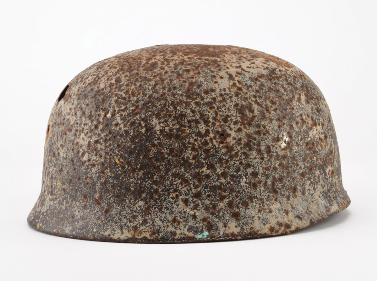 A German Fallschirmjager helmet from the Ramcke Brigade, found in position and exposed by blowing sands.