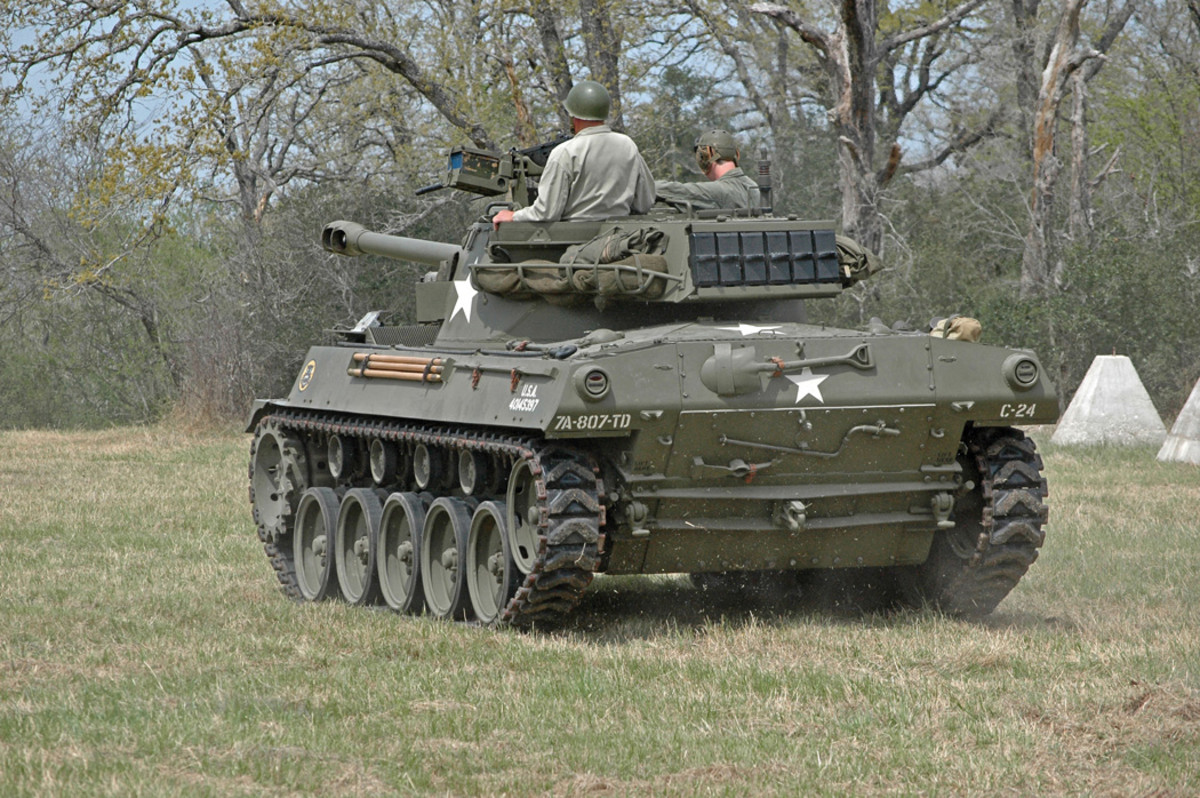 Mullins’ 76mm GMC M18 gives a sense of the fairly small scale and low profile of this type of vehicle. Visible markings include the U.S. Army registration number 40145397 toward the rear of the hull, markings the 807th Tank Destroyer Battalion of the 7th Army, on the left of the rear of the hull, and markings for the 24th vehicle in Company C on the right of the rear of the hull. Stowed on the rear of the hull are a shovel, a pick-axe head, and a hand crank for manually rotating the engine  and clearing oil from the lower cylinders before starting.
