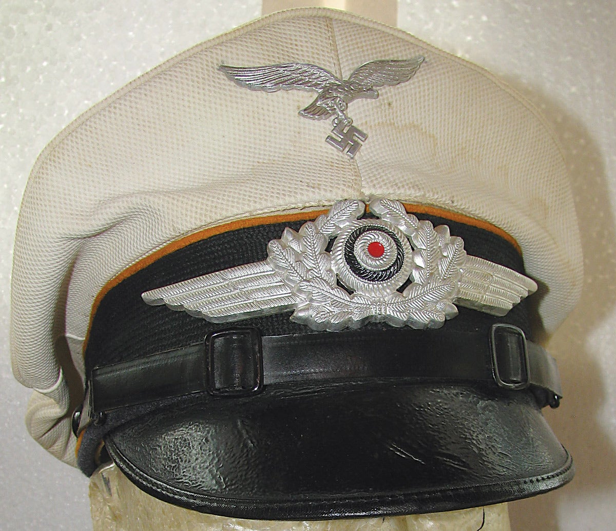 A Luftwaffe enlisted white-topped visor cap piped in yellow indicating flying aircrew soldiers and paratroopers. These lighter caps were worn during the summer months.